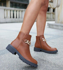 Brown ankle boots adorned with a chain