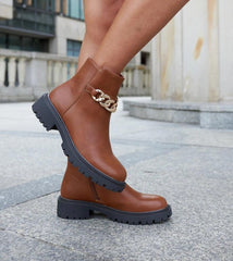 Brown ankle boots adorned with a chain