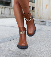 Brown ankle boots adorned with a chain