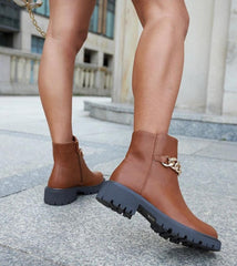 Brown ankle boots adorned with a chain